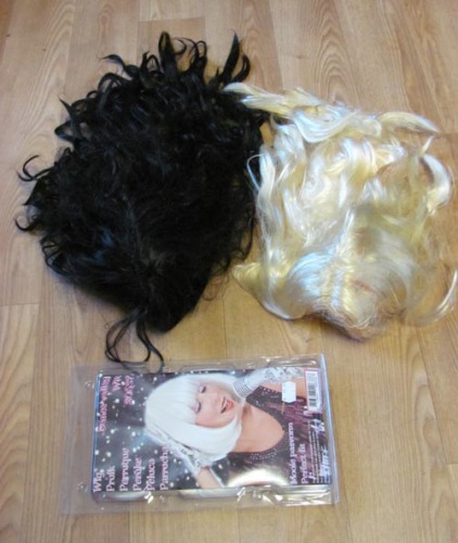 Zwarte, blonde en grijze pruik. De blonde heeft wat rode vegen. De grijze is nieuw (niet uit de verpakking geweest).